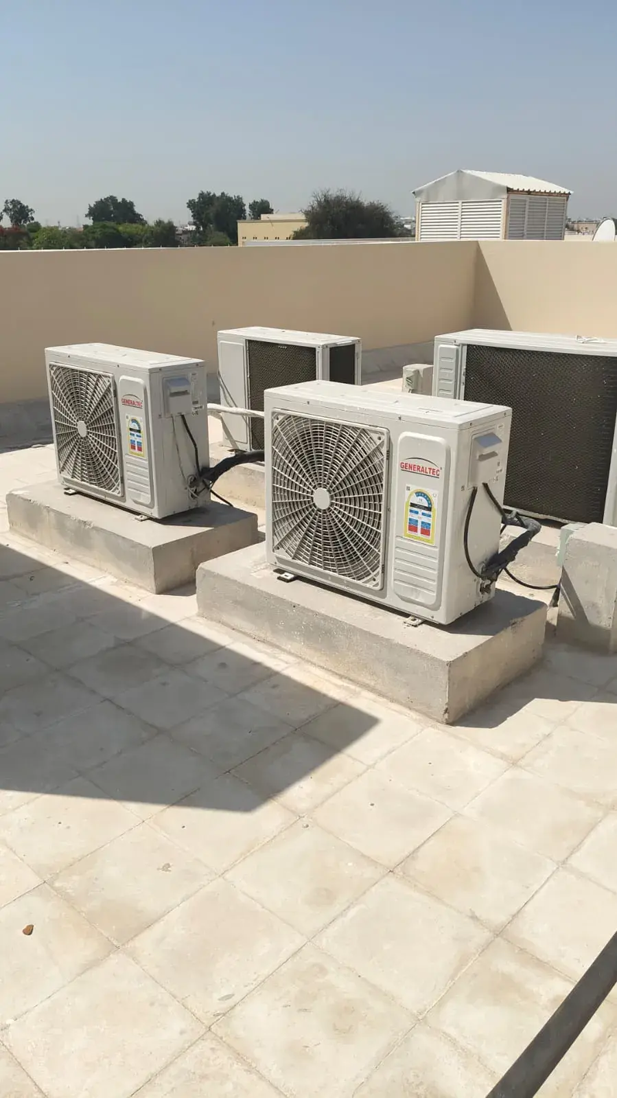 Split AC outdoor units on raised concrete bases
