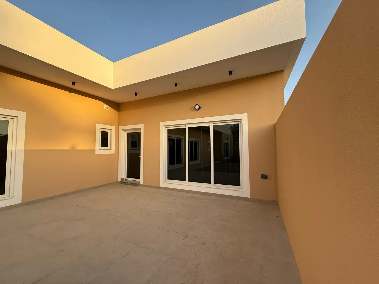 Villa courtyard at golden hour with sliding doors, built by Modern Bridge
