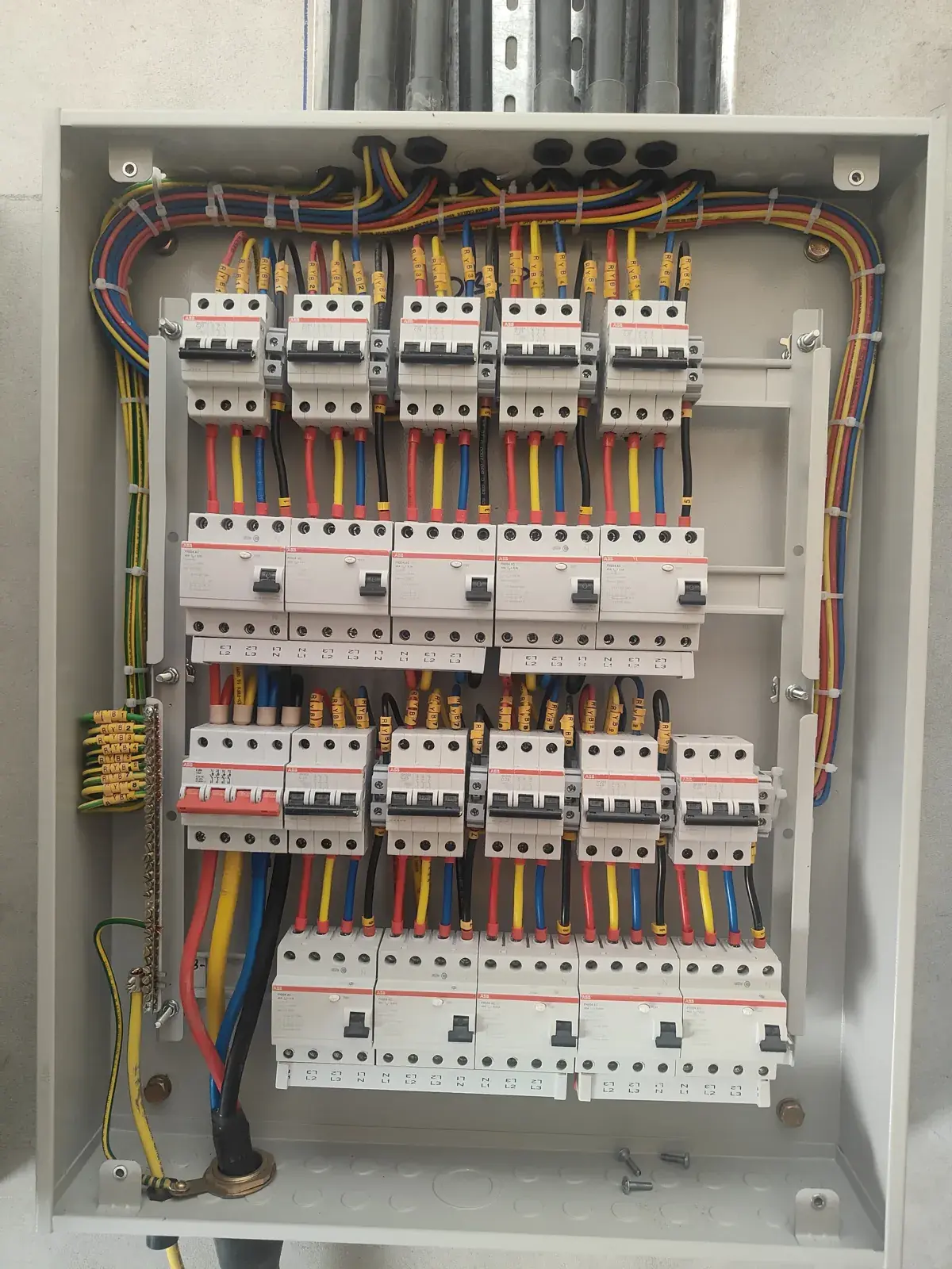 Distribution board installed by Modern Bridge with neatly dressed red, yellow and blue cabling and rows of breakers