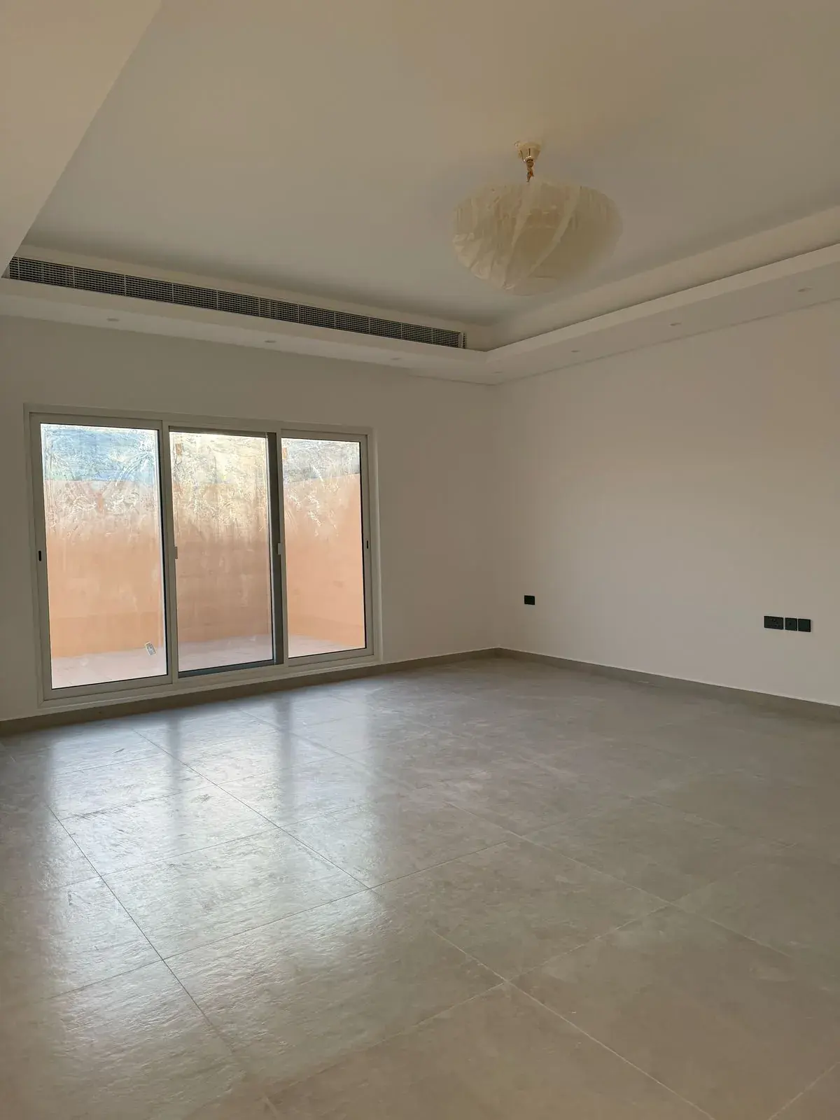 Room with gypsum ceiling, chandelier and sliding doors